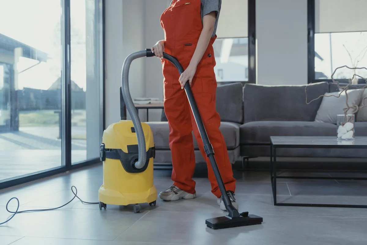 Illustrative category photo of a professional cleaner vacuuming a living room