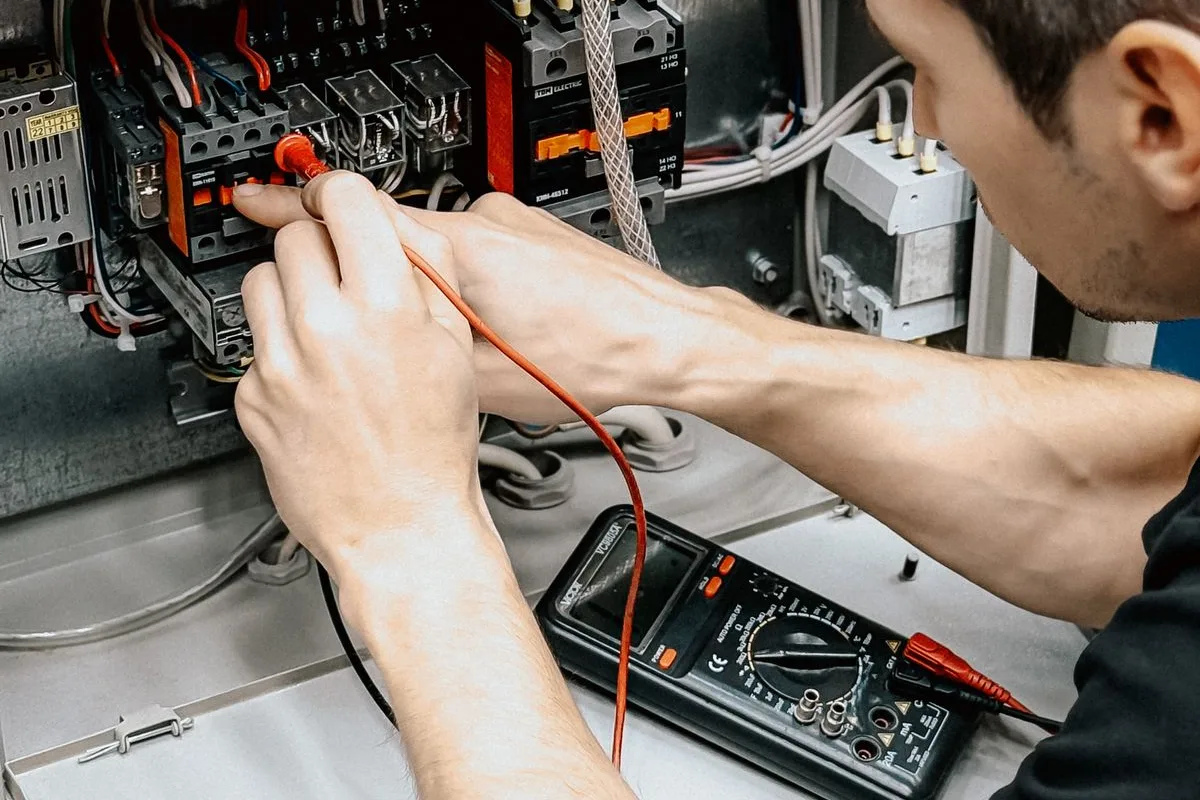 Illustrative category photo of an electrician testing an electrical panel